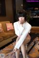 A woman sitting on a coffee table in a living room.