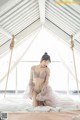 A woman sitting on top of a bed in a room.