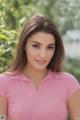 A woman in a pink shirt posing for a picture.