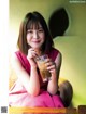 A woman sitting at a table with a glass of iced coffee.