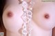 a close up of a woman's breasts with pearls on it