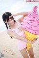 A woman in a pink bathing suit holding an ice cream cone.