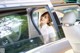 A woman sitting in the back seat of a car looking out the window.