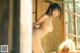 A naked asian woman standing in front of a window.