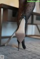 A close up of a woman's legs wearing black high heels.