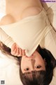 A woman laying on top of a white bed.