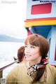 A woman wearing a scarf standing on a boat.