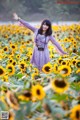 A woman standing in a field of sunflowers with her arms outstretched