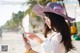 A woman in a purple hat looking at her cell phone.