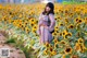 A woman standing in a field of sunflowers.