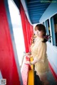 A woman standing on the side of a boat looking out the window.