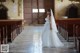 A woman in a wedding dress standing in a church.