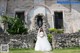 A woman in a wedding dress standing in front of a church.