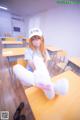 A girl sitting on a desk in a classroom.