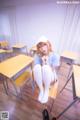 A woman sitting on a chair in a classroom.