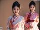 A couple of women in traditional korean clothing standing next to each other.